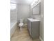 Bathroom features a gray single sink vanity with a marble shower and wood-look floors at 788 Fayetteville Se Rd, Atlanta, GA 30316