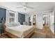The primary bedroom with blue walls, wood flooring, natural light, and a cozy seating area at 2647 Forrest Nw Ave, Atlanta, GA 30318