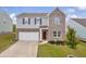 Two story home featuring a brick and gray facade, attached garage, and a well manicured lawn at 3828 Ramsay Pass, Loganville, GA 30052