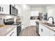 Kitchen with stainless steel appliances, granite countertops, and white cabinetry and hardware at 3828 Ramsay Pass, Loganville, GA 30052