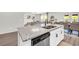 Kitchen island with granite countertops, stainless steel dishwasher, cabinets with black hardware at 3828 Ramsay Pass, Loganville, GA 30052