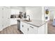 Kitchen island offers a view of the living room and fireplace with bright white cabinets at 3828 Ramsay Pass, Loganville, GA 30052