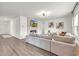 Bright living room features a fireplace, TV, light gray sofa, light fixture and wood flooring at 3828 Ramsay Pass, Loganville, GA 30052