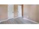 Bedroom features laminate flooring, neutral wall paint, and two doors at 5805 Eagles Feather Ln, Riverdale, GA 30274