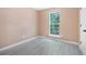 Bedroom features window, white door, neutral wall paint, and laminate flooring at 5805 Eagles Feather Ln, Riverdale, GA 30274