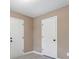 A bedroom with neutral paint, wood-look flooring, and two doors at 5805 Eagles Feather Ln, Riverdale, GA 30274