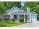 Charming single Gathering home with light blue siding, lush lawn, and welcoming front porch at 5805 Eagles Feather Ln, Riverdale, GA 30274