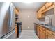 Galley kitchen with stainless steel appliances, granite counters, and wood cabinets at 5805 Eagles Feather Ln, Riverdale, GA 30274