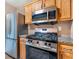 Cozy kitchen with stainless steel appliances, granite counters, and oak cabinets at 5805 Eagles Feather Ln, Riverdale, GA 30274