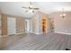 Open living room with hardwood floors, neutral walls, multiple doors, and chandelier at 5805 Eagles Feather Ln, Riverdale, GA 30274