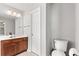 Bathroom features a white vanity with wood cabinets, a toilet, and modern lighting at 720 Mountain Laurel Dr, Canton, GA 30114