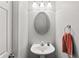 Powder bathroom features modern fixtures, vanity lighting, framed mirror, and pedestal sink at 720 Mountain Laurel Dr, Canton, GA 30114
