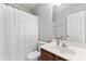 This bathroom features a shower with a curtain, a white sink, and cherry-toned vanity at 720 Mountain Laurel Dr, Canton, GA 30114