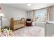Adorable Bedroom with a wooden crib, rocker, patterned rug, and plenty of natural light at 720 Mountain Laurel Dr, Canton, GA 30114