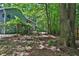 A lush green backyard with mature trees and a covered patio area at 3067 Nuptial Ln, Lawrenceville, GA 30044