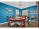 Stylish dining room featuring wood floors, a round table, and unique turquoise accent wall at 3067 Nuptial Ln, Lawrenceville, GA 30044