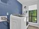Laundry room with modern washer/dryer, a storage shelf, and a view of the outdoors at 3067 Nuptial Ln, Lawrenceville, GA 30044