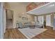 Bright living room featuring high ceilings, wood floors, a comfortable gray sofa, and a view of the upper level at 3067 Nuptial Ln, Lawrenceville, GA 30044
