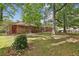 Brick home's backyard with mature trees and an open lawn at 4074 Idlevale Dr, Tucker, GA 30084