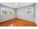Bedroom features hardwood floors, two windows, neutral paint, and closet at 4074 Idlevale Dr, Tucker, GA 30084