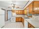 Functional kitchen with white appliances, wood cabinets and tile flooring illuminated by a ceiling fan at 4074 Idlevale Dr, Tucker, GA 30084