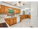 Cozy kitchen with wood cabinets, white appliances, and tile floors, complemented by a ceiling fan and natural light at 4074 Idlevale Dr, Tucker, GA 30084