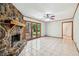 Living room with stone fireplace, tile floors, backyard access, and nearby dining area at 4074 Idlevale Dr, Tucker, GA 30084