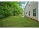 Home exterior showcasing a well-maintained backyard with lush green grass and mature trees at 6297 Polar Fox Ct, Riverdale, GA 30296