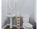 Powder room featuring a pedestal sink, oval mirror and small cabinet for storage at 6297 Polar Fox Ct, Riverdale, GA 30296