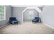 Bonus room featuring two blue accent chairs and carpeting at 6297 Polar Fox Ct, Riverdale, GA 30296