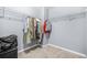 Spacious walk-in closet with ample hanging space, carpet floors, and gray walls at 6297 Polar Fox Ct, Riverdale, GA 30296