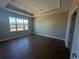 Spacious bedroom with tray ceiling, dark wood floors and a large window at 1001 Calypso Way # 1001, Cumming, GA 30040