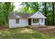 Quaint house with a welcoming front porch, set amongst mature trees at 1025 Cheaves St, Forest Park, GA 30297