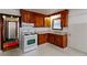 Compact kitchen featuring wooden cabinets and a white gas range at 1025 Cheaves St, Forest Park, GA 30297