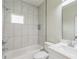 Bright bathroom with white marble-style tiled shower/tub and vanity with quartz countertop at 2621 Oldknow Nw Dr, Atlanta, GA 30318