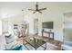 Sunlit living room boasts vaulted ceilings, sleek fan, and flows into kitchen and dining at 2621 Oldknow Nw Dr, Atlanta, GA 30318