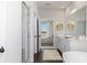 Well-lit bathroom with a glass door shower, large mirror, double sinks, and hardwood flooring at 509 Altamaha Ct, Locust Grove, GA 30248