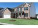 Brick two-story home with landscaped front yard, attached garage, and covered porch with white columns at 509 Altamaha Ct, Locust Grove, GA 30248