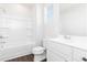 Bathroom with white tub/shower combo and white vanity against wood look flooring at 736 Ocmulgee Xing, Locust Grove, GA 30248