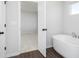 Modern bathroom featuring a freestanding tub, an open doorway, and contemporary finishes at 736 Ocmulgee Xing, Locust Grove, GA 30248