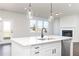 Bright kitchen with an island, sink, stylish pendant lighting, and stainless appliances at 736 Ocmulgee Xing, Locust Grove, GA 30248