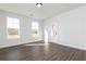Sunlit living room showcasing hardwood floors and a charming white door at 736 Ocmulgee Xing, Locust Grove, GA 30248