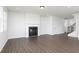 Open-concept living room with a fireplace, large windows, and hardwood floors at 736 Ocmulgee Xing, Locust Grove, GA 30248