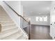 Open-concept living room with staircase, hardwood floors, and ample natural light at 736 Ocmulgee Xing, Locust Grove, GA 30248