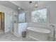 Bright bathroom featuring a modern tub, walk-in shower, decorative window and tiled floors at 1830 Hadfield Blvd, Roswell, GA 30075