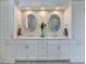 Elegant bathroom boasts a double vanity, contemporary lighting, and white cabinetry at 1830 Hadfield Blvd, Roswell, GA 30075