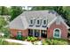 Charming brick home with a covered porch, manicured landscaping, and a well-maintained lawn at 1830 Hadfield Blvd, Roswell, GA 30075