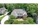 A brick two-story home with a manicured lawn and mature trees at 1830 Hadfield Blvd, Roswell, GA 30075