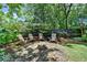 Cozy fire pit area with Adirondack chairs, perfect for outdoor gatherings in a beautifully landscaped backyard at 1830 Hadfield Blvd, Roswell, GA 30075