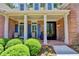 Inviting front porch with brick flooring, white columns, and rocking chairs, showcasing a welcoming entryway at 1830 Hadfield Blvd, Roswell, GA 30075